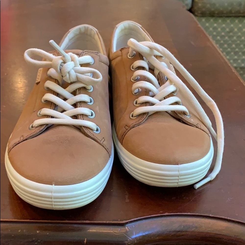 Ecco laced up tennis shoes .